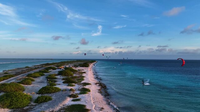 Aerial view of beautiful tropical island beach with kitesurfers and serene ocean, Caribbean.