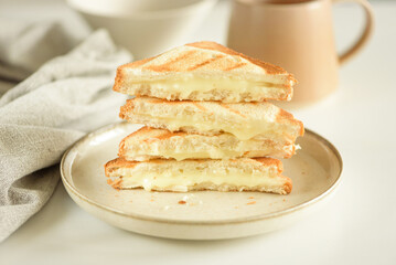 Stack of melted cheese sandwich on white table