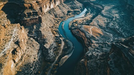 Aerial view of a winding river through rocky canyons and rugged terrain.