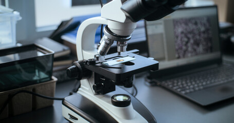 Workspace in advanced modern archaeological lab. Microscope with sample on glass slide for fossil...