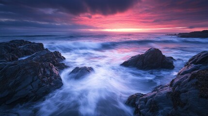 Fototapeta premium Serene coastal sunset with waves crashing against rocky shore.