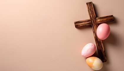Wooden cross and painted Easter eggs on beige background