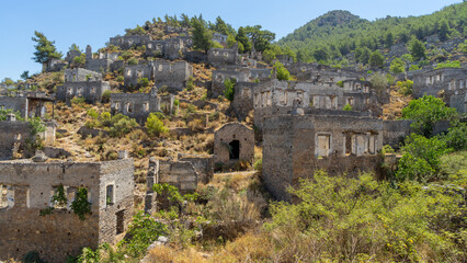 Fototapeta premium Destroyed walls of houses in abandoned town or village Kayakoy, neighbourhood of municipality and district of Fethiye, Mugla Province, Turkey