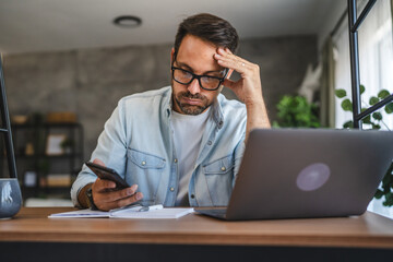 Obraz premium Man stressed while look at mobile phone, read a bad news