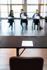 Empty interview table with paper and pen