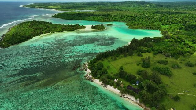 Aerial view of a secluded tropical island with lush greenery and azure waters, Shefa Province, Vanuatu.