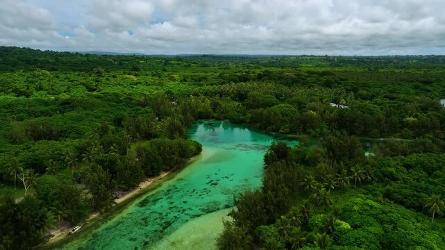 Aerial view of a serene blue hole surrounded by lush green forest and clouds in the sky, Shefa Province, Vanuatu.