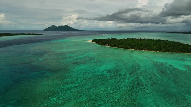Aerial view of a tropical island with a crystal clear lagoon, lush palms, and a beautiful reef, Shefa Province, Vanuatu.