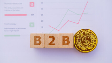 Three wooden cubes with the word B2B placed on graph sheet, abbreviation of Business to Business....