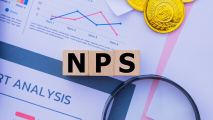 Three wooden cubes with the word NPS on graph sheets, abbreviation for Net Promoter Score. Business...