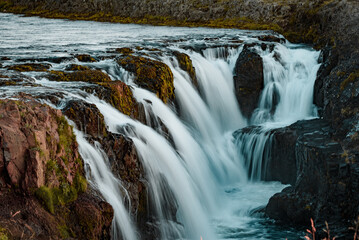 Serene Waterfall in Lush Green Landscape with Mossy Rocks