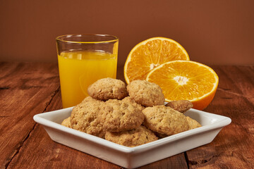 Homemade orange-flavored cookies accompanied by a glass of fresh orange juice