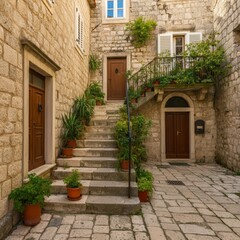 Fototapeta premium Old stone building with stairs lined with potted plants leading to the doorways of residential apartments in the medieval island town of Croatia
