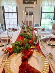 Dining Table With Plates, Glasses, And Candles With Orange Red Floral Theme
