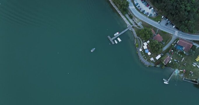 Aerial view of serene Viverone Lake surrounded by greenery and boats, Viverone, Italy.
