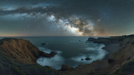 Obraz premium A stunning panoramic view of the Milky Way over a coastal landscape at night.