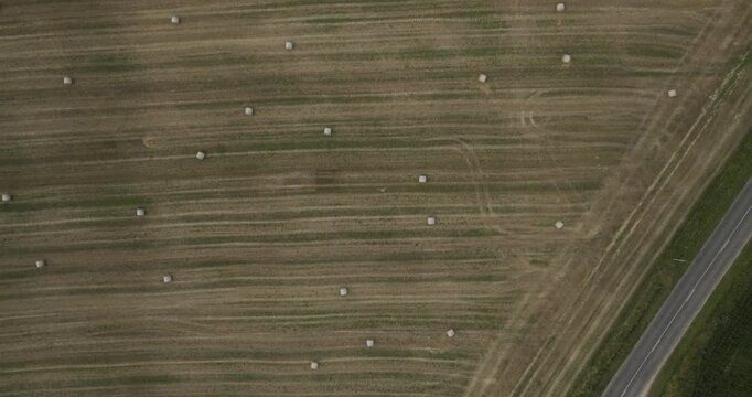 Aerial view of a picturesque countryside with haystack fields and winding roads, Varennes-Saint-Sauveur, France.