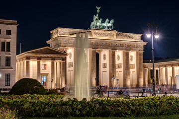 Obraz premium The illuminated Brandenburg Gate in Berlin with fountain at night