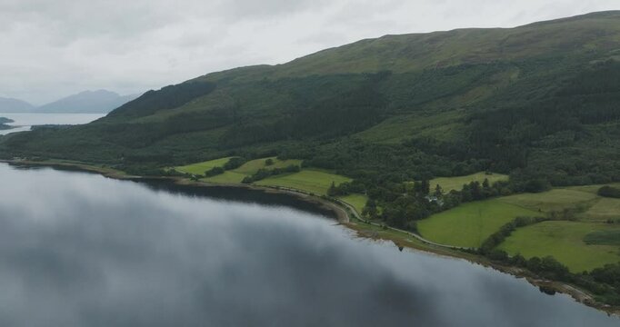 Aerial view of serene Loch Leven surrounded by majestic mountains and lush greenery, Glencoe, Scotland.