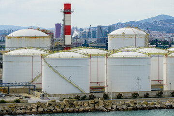 Many large round white reservoirs of chemical products in the port industrial terminal