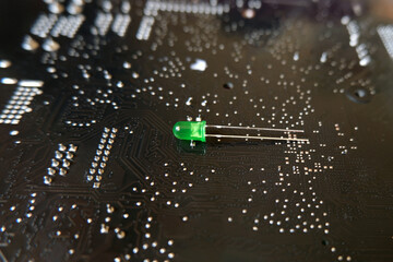 Single green Light Emitting Diode (led) standing on the high technology patterned floor.