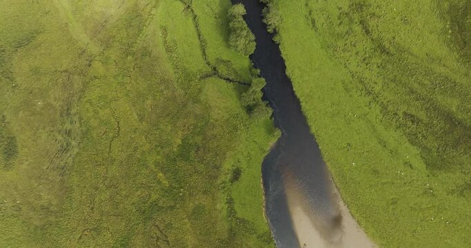 Aerial view of Loch Tulla surrounded by lush green trees and a tranquil valley, Bridge of Orchy, Scotland.
