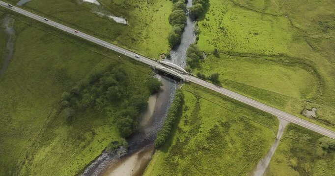 Aerial view of the tranquil Loch Tulla with a winding river and lush green countryside, Bridge of Orchy, Scotland.