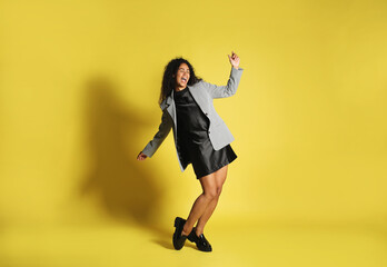 Beautiful woman in stylish jacket on yellow background