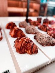 Croissants and pastries in the window of a coffee shop. Stand with croissants in a store. Concept of croissants and pastries
