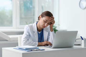 Tired nurse sleeping at white table in clinic