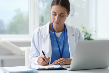 Nurse taking notes at table in clinic