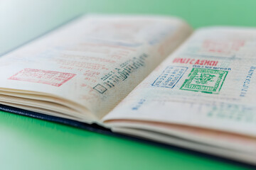 Fototapeta premium Multiple Customs Stamps Scattered on an Open Passport, Travel History and Global Journeys