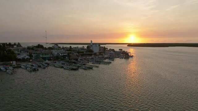 Aerial view of a beautiful coastal town at sunset with serene water and boats in the harbor, Progreso, Mexico.