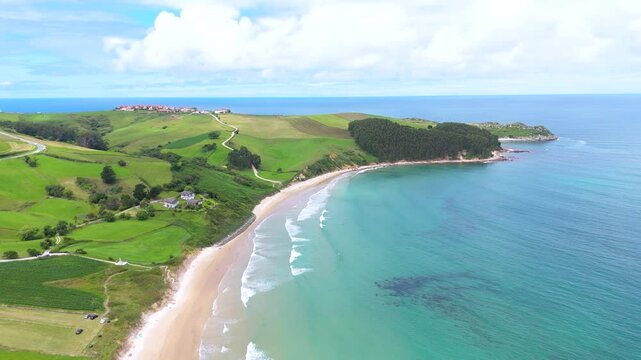 Aerial drone view of surfers surfing at Playa Oyambre at the Cantabrian Sea, San Vincente, Spain