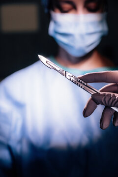 Surgeon holding a scalpel in surgery