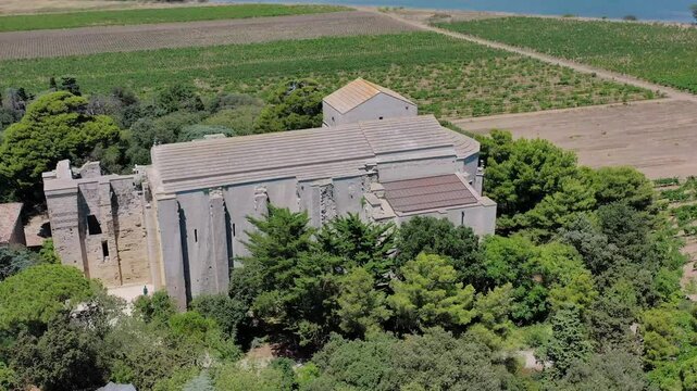 Aerial view of the beautiful Cathedral of Maguelone St Pierre and St-Paul surrounded by greenery and forest, Monpellier, France.