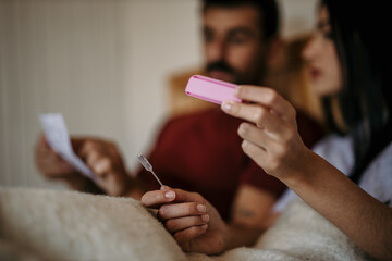 Obraz premium A loving couple is opening a pregnancy test, reading the instructions, and about to use it.