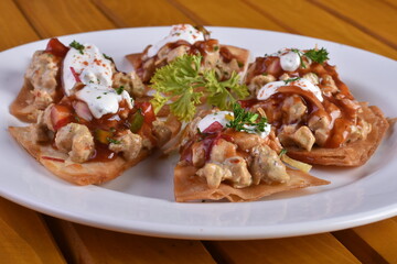Mexican nacho chips baked with chicken, black beans and cheese on a plate top view