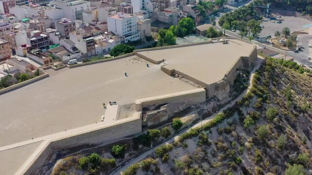 Aerial view of the historic guardamar castle surrounded by the scenic town and lush vegetation, Guardamar del Segura, Spain.