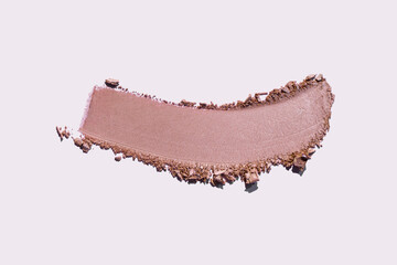 Cosmetic product swatch. Smudge of eye shadow beige brown blush, bronzer or loose or compact pressed powder isolated on gray pink  background