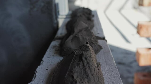 Worker applies brick glue with a trowel