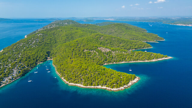 An aerial view of the beautiful beach on Zlarin Island, Croatia. This quiet beach, surrounded by lush greenery and crystal-clear waters, offers a peaceful retreat for visitors