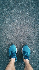 Fototapeta premium A top-down view of a runner's feet on a running path, highlighting the shoes and the ground texture, with a light solid color background