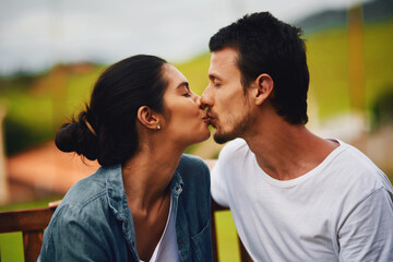 Love, kiss and bonding with couple in park for romance, peace and summer vacation. Happiness, commitment and care with man and woman relax on date in nature for marriage, support and partnership