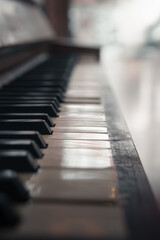 Closeup with shallow depth of field of the keyboard of an old real wooden piano.