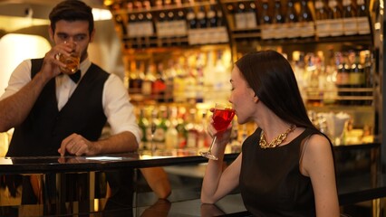 Bartender serving mixed vodka Cosmopolitan red cocktail decorated with flower making cheers with beautiful guest sitting at luxurious counter bar perfect vibrant color atmosphere nightclub. Vinosity.