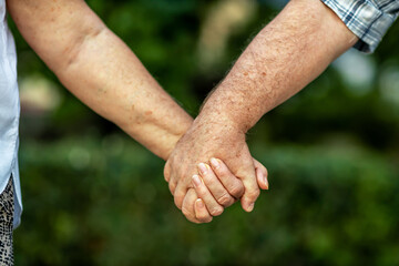 The hands of an elderly couple who have carried love and tenderness through life.