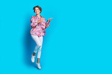 Full body photo of stunning cheerful lady indicate fingers empty space proposition isolated on blue color background
