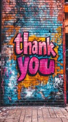 A colorful thank you mural stands out against a textured brick wall, showcasing vibrant graffiti...