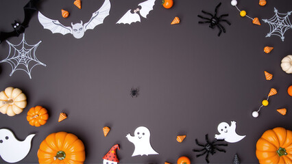 Halloween frame of scattered halloween party decor. Top down view over an grey background with copy space.